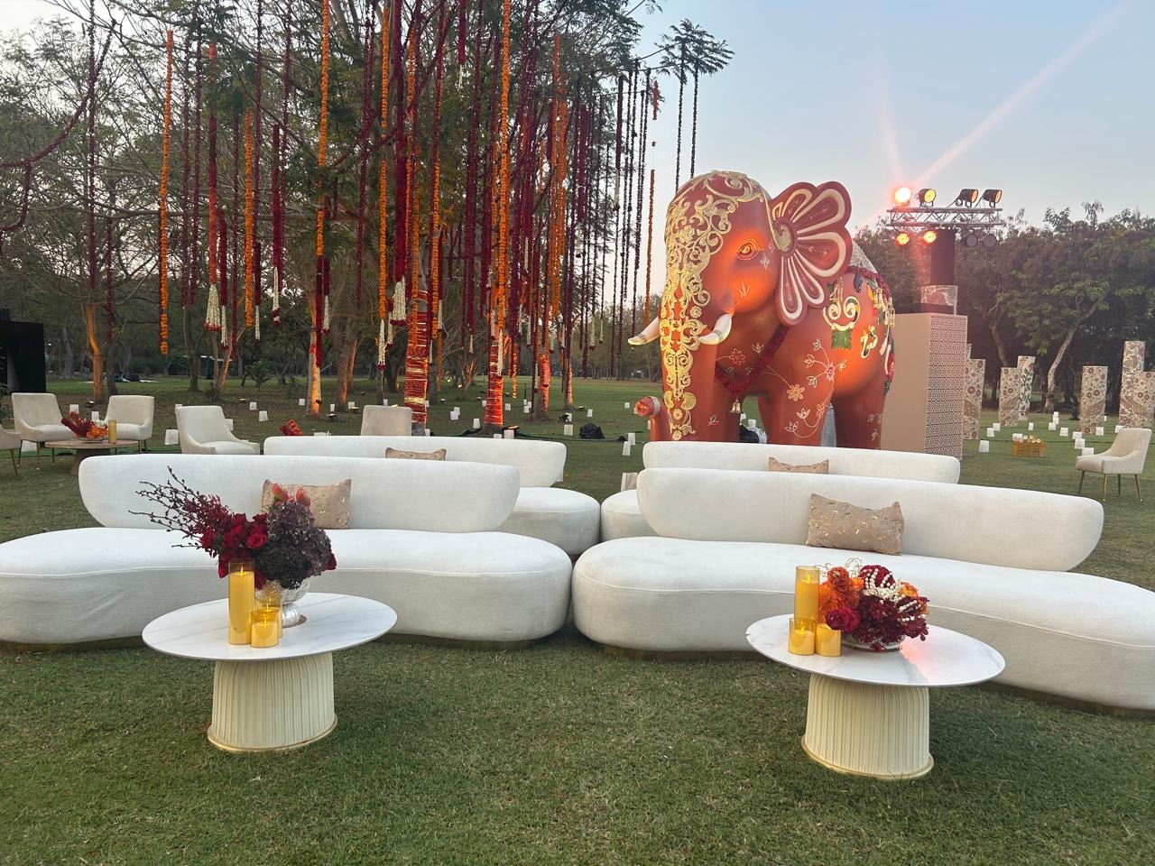 Arjun Tendulkar wedding at Vantara — outdoor garden with white lounges and hanging marigolds