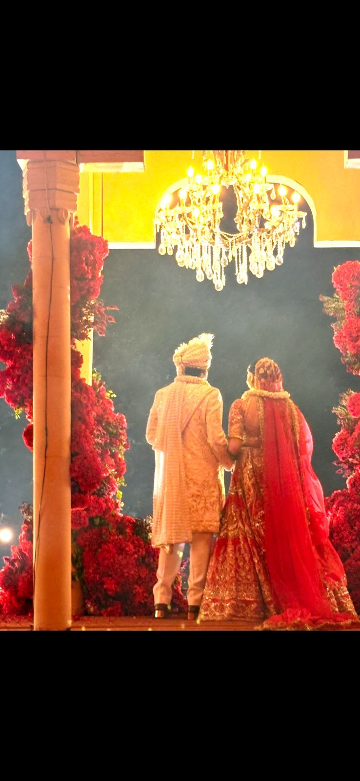 Wedding ceremony at Mehrangarh Fort Jodhpur — couple at mandap under night sky with red flower walls