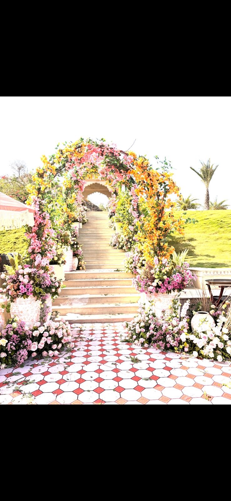 Sharma wedding at Fairmont Udaipur — floral arch entrance with yellow and pink flowers